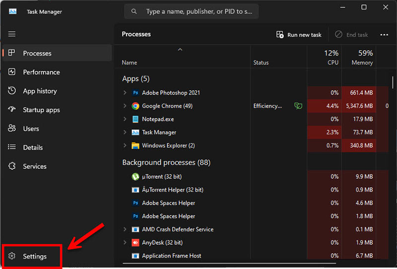 หน้าจอ Task Manager ของ Windows 11 แสดงแท็บ Processes โดยมีกรอบสีแดงและลูกศรชี้ไปที่เมนู Settings (ไอคอนรูปเฟือง) บริเวณมุมซ้ายล่างของหน้าจอ